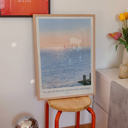 We Are Never Ever Getting Back Together Taylor Swift print of a red sailboat, on an orange stool beside tulips