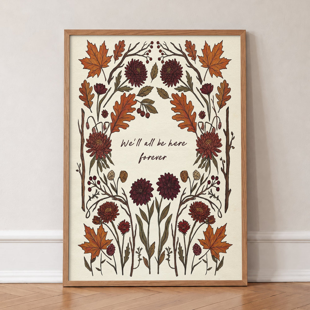 We'll All Be Here Forever Noah Kahan lyric print with a border of autumn leaves and dahlias, in an oak frame, leaning against a wall on a herringbone floor