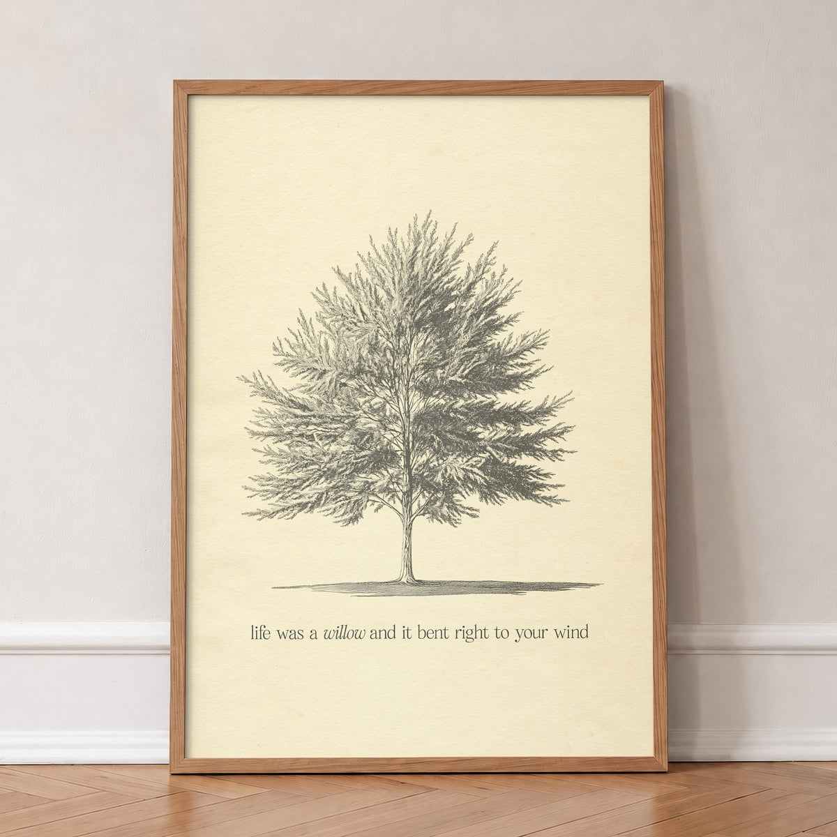 Willow Minimal Taylor Swift print of a pencil-sketched tree above a line from the song, in an oak frame, leaning against a wall on a herringbone floor
