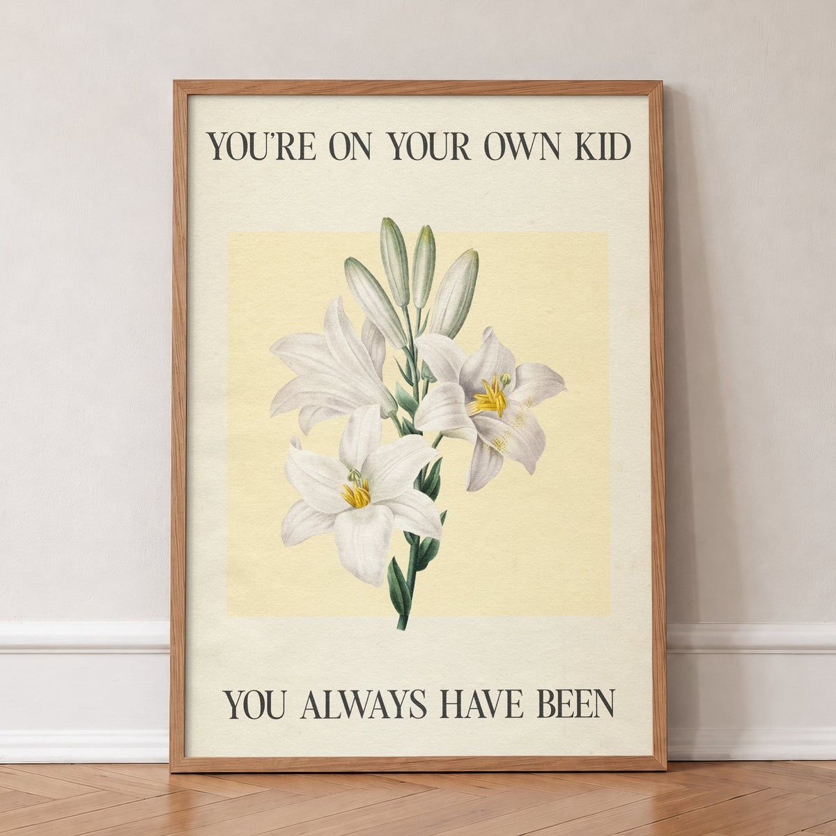 You’re On Your Own Kid Botanical Taylor Swift lyric print of white lilies on yellow, in an oak frame, leaning against a wall on a herringbone floor